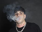 Intervista a Beak on The Night, producer e direttore artistico di Daytona KK a man with tattoos smoking